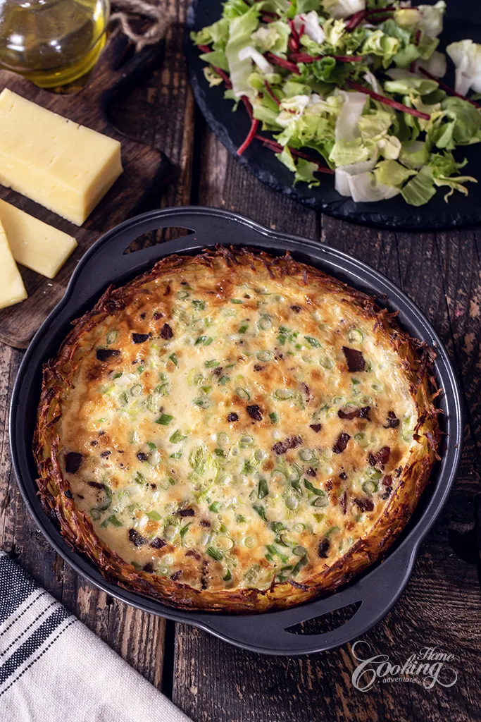 Potato crust quiche with cheese and bacon served with fresh salad