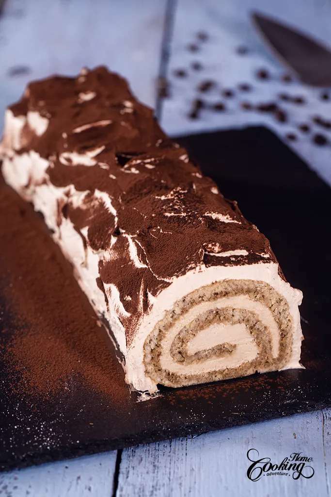 Tiramisu Cake Roll with whipped cream topping and dusted with cocoa powder