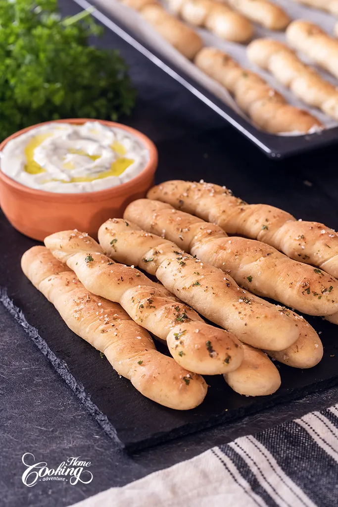 homemade breadsticks with olive oil, garlic and herbs with tzatziki sauce