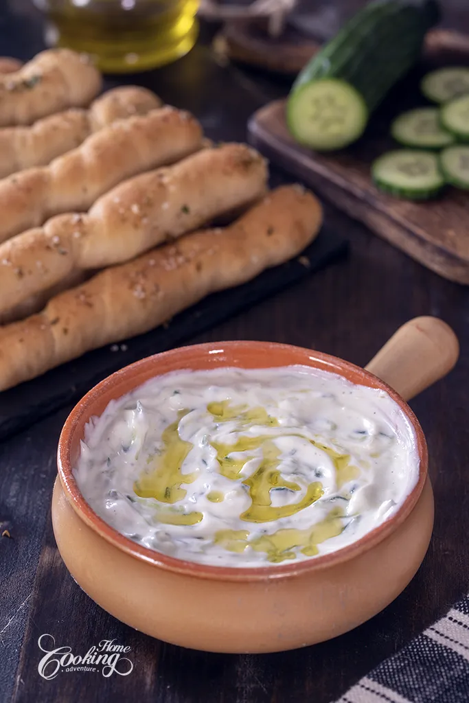 Greek Tzatziki Sauce with homemade bread sticks and a drizzle of olive oil.